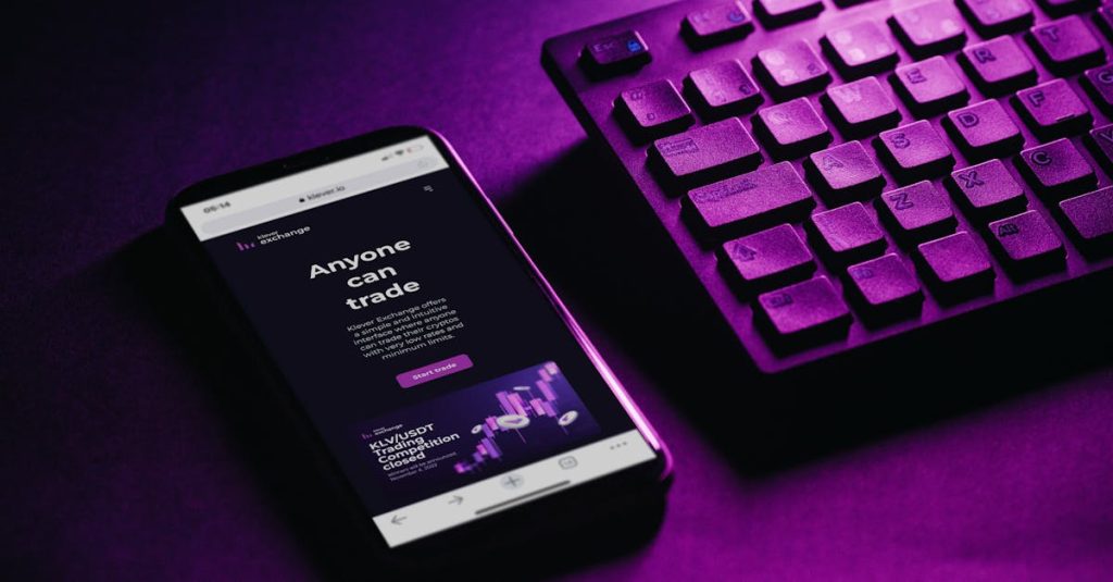 Close-up of a smartphone and keyboard with a purple hue, embodying modern technology and connectivity.